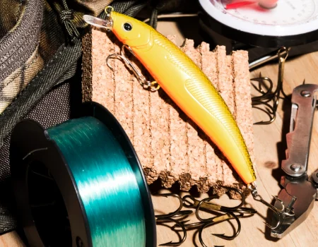 Imagem de acessórios diversos como carretéis de linhas, iscas artificiais, alicates, entre outros